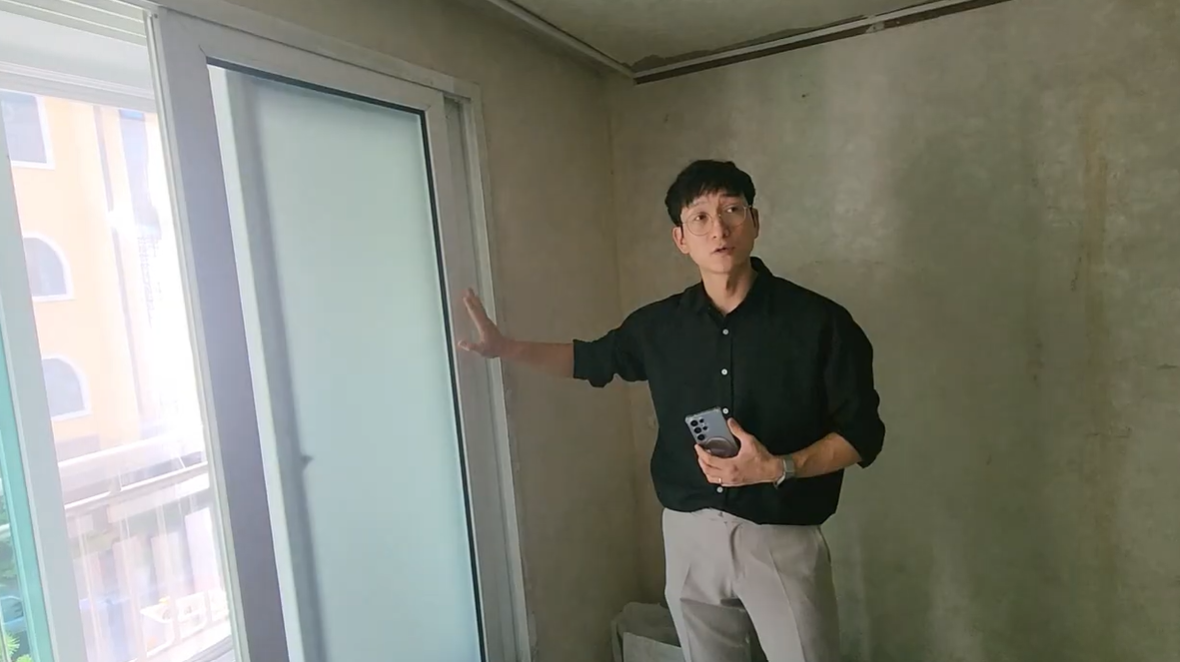 공사 중인 방에서 창호와 현장 상태를 설명하는 강사